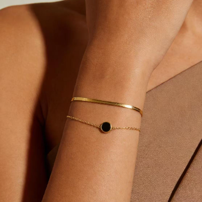 Gold double layer bracelet set with black agate worn on wrist, minimalist chain and bangle jewelry for women