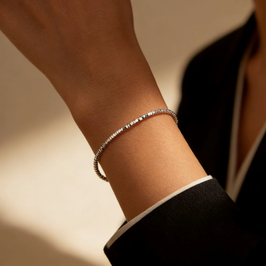 Silver break bead bracelet worn on wrist, minimalist shimmering segment bead jewelry for women