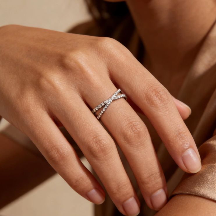 Silver crossover pave moissanite ring worn on finger, minimalist dainty moissanite stacking jewelry for women