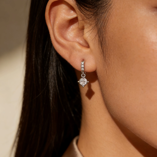 Silver mini three-stone moissanite drop hoop earrings worn on ear, minimalist dainty moissanite layering jewelry for women