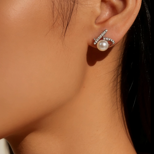 Silver pearl & moissanite heart stud earrings worn on ear, minimalist dainty heart jewelry for women