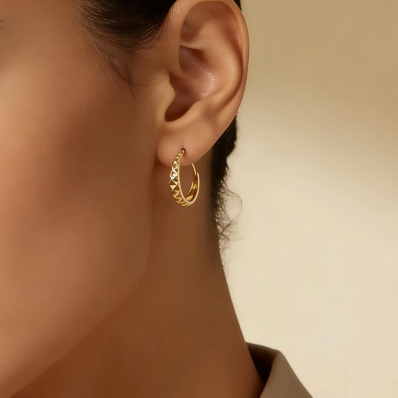 Gold diamond cut small huggie hoop earrings worn on ear, minimalist everyday jewelry for women