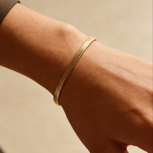 Gold herringbone chain bracelet worn on wrist, minimalist everyday jewelry for women