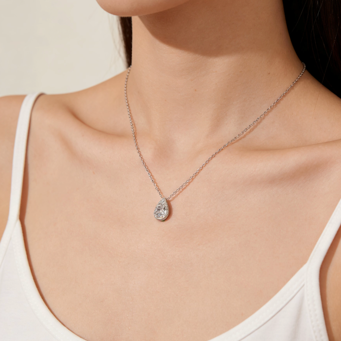 Silver mini pear-shaped halo moissanite pendant necklace worn on neck, minimalist dainty moissanite layering jewelry for women