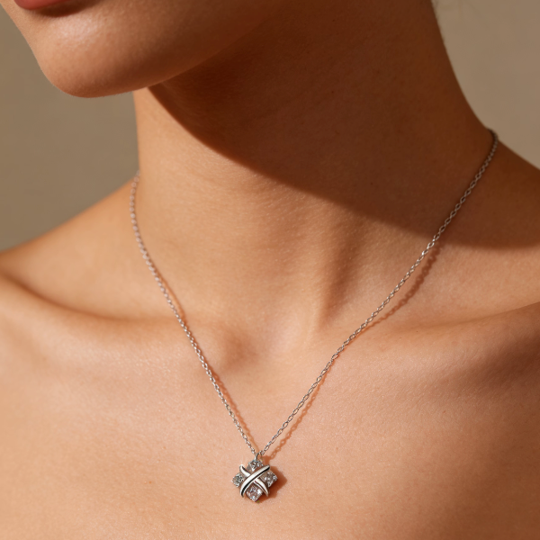 Silver moissanite criss-cross four-leaf clover necklace worn on neck, minimalist X-design moissanite four-leaf clover pendant jewelry for women
