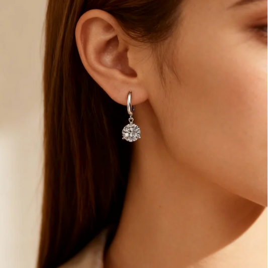 Silver moissanite huggie drop earring worn on ear, sparkling round cut dangle jewelry for women