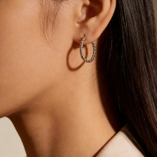 Silver twist rope chain hoop earrings worn on ear, minimalist braided hoop jewelry for women