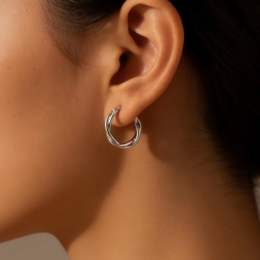 Silver twisted hoop earrings worn on ear, minimalist multi-strand twist layering jewelry for women